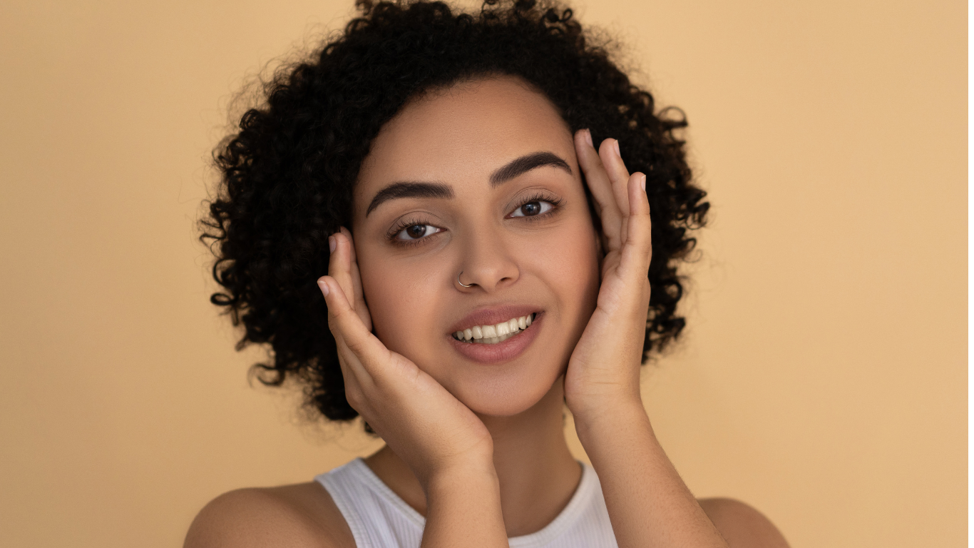 woman with nose ring and hands on face